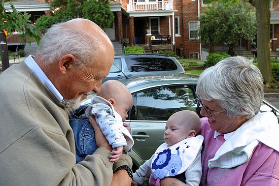 The grandparents show the boys to each other.